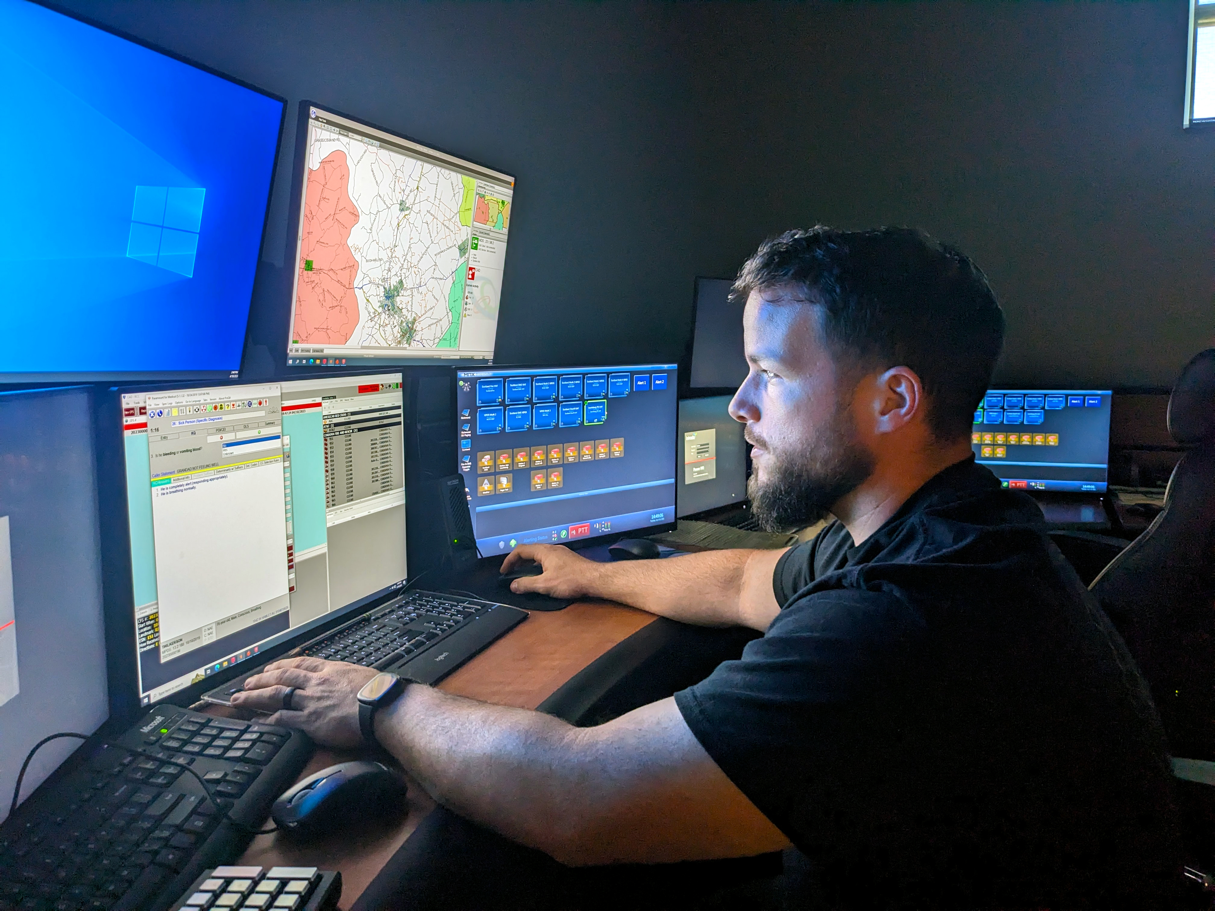 An operator monitors several computers in the 911 call center.